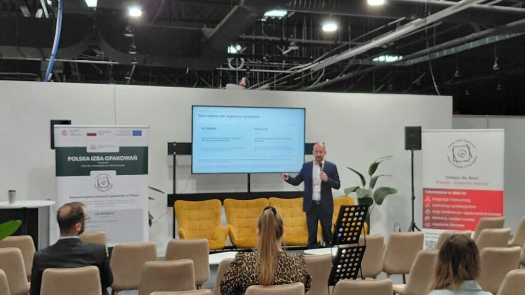 Krzysztof Niczyporuk, Prezes Polskiej Izby Opakowań, podczas wystąpienia o PPWR na konferencji Izby na targach PETFOOD Tech Expo 2026; na ekranie slajd „Dwie mylone role: wytwórca a producent”
