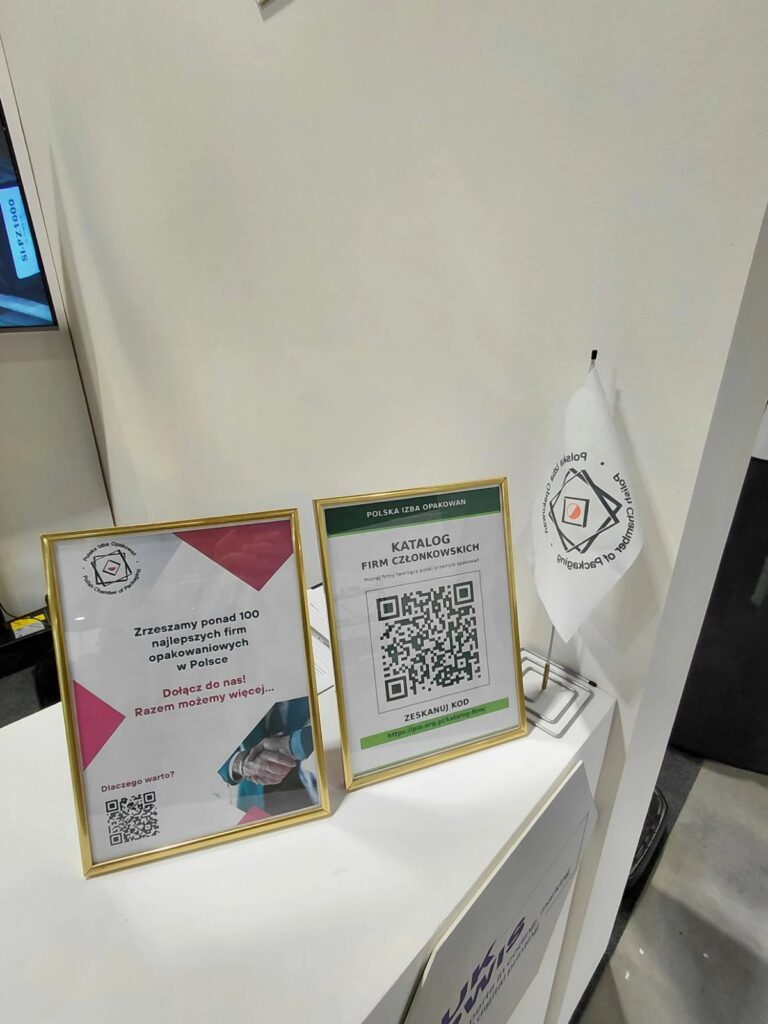 Stoisko Polskiej Izby Opakowań na targach PETFOOD Tech Expo 2026: tabliczki „Zrzeszamy ponad 100 najlepszych firm opakowaniowych w Polsce” i „Katalog firm członkowskich” z kodem QR