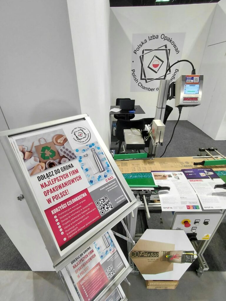 Stoisko Polskiej Izby Opakowań na targach PETFOOD Tech Expo 2026: pokaz znakowania opakowań zbiorczych na przenośniku, przygotowany przez firmę członkowską DRUK SERWIS 24 Sp. z o.o.